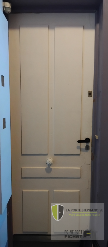 Installation d'une porte de sécurité dans le quartier de La Terrasse à Saint-Étienne par La Porte Stéphanoise. Remplacement d'une ancienne porte moulurée par une porte de sécurité qui améliore l'isolation thermique et phonique et est coupe feu 30 minutes. Photo extérieur de l'ancienne porte.