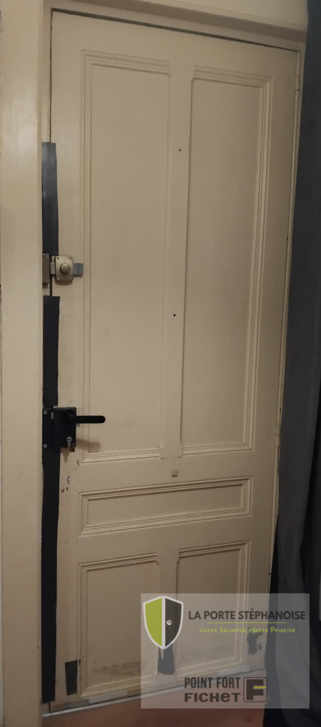 Installation d'une porte de sécurité dans le quartier de La Terrasse à Saint-Étienne par La Porte Stéphanoise. Remplacement d'une ancienne porte moulurée par une porte de sécurité qui améliore l'isolation thermique et phonique et est coupe feu 30 minutes. Photo intérieur de l'ancienne porte.